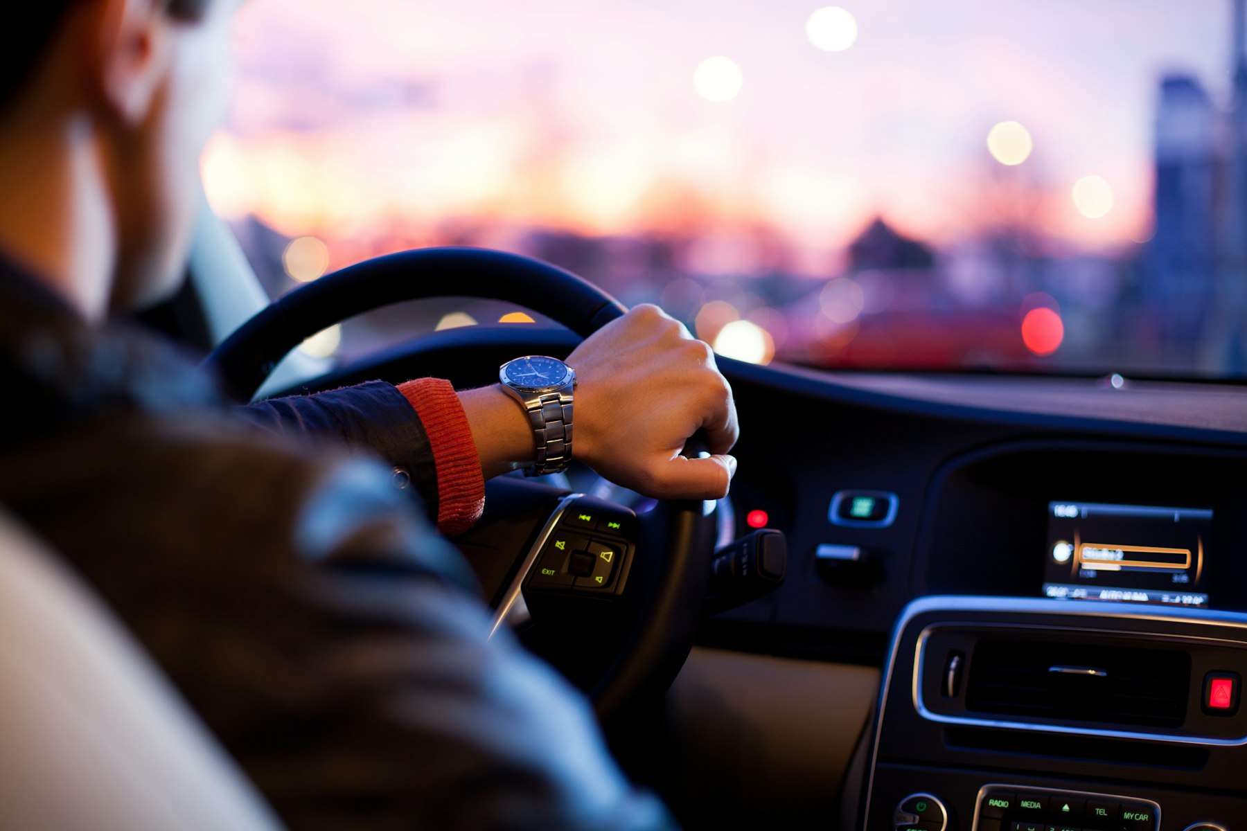Headlights cutting through warm dusk on an open road